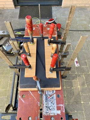 De twee planken worden met lijmklemmen tegen elkaar gedrukt.