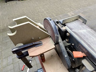 Even een hulpstuk gemaakt uit resthout, om juiste hoek af te schuinen. Hoek is 54 graden, de maximale hoek bij opmaatzagen is 46 graden, wat te weinig is, dus laatste stukje moet geschuurd worden.