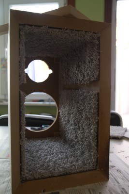 Tapijttegel aan de wanden gekleefd en opening gelaten voor de bracing