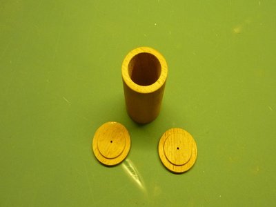De houten kokers met twee deksels met een gaatje voor de draden